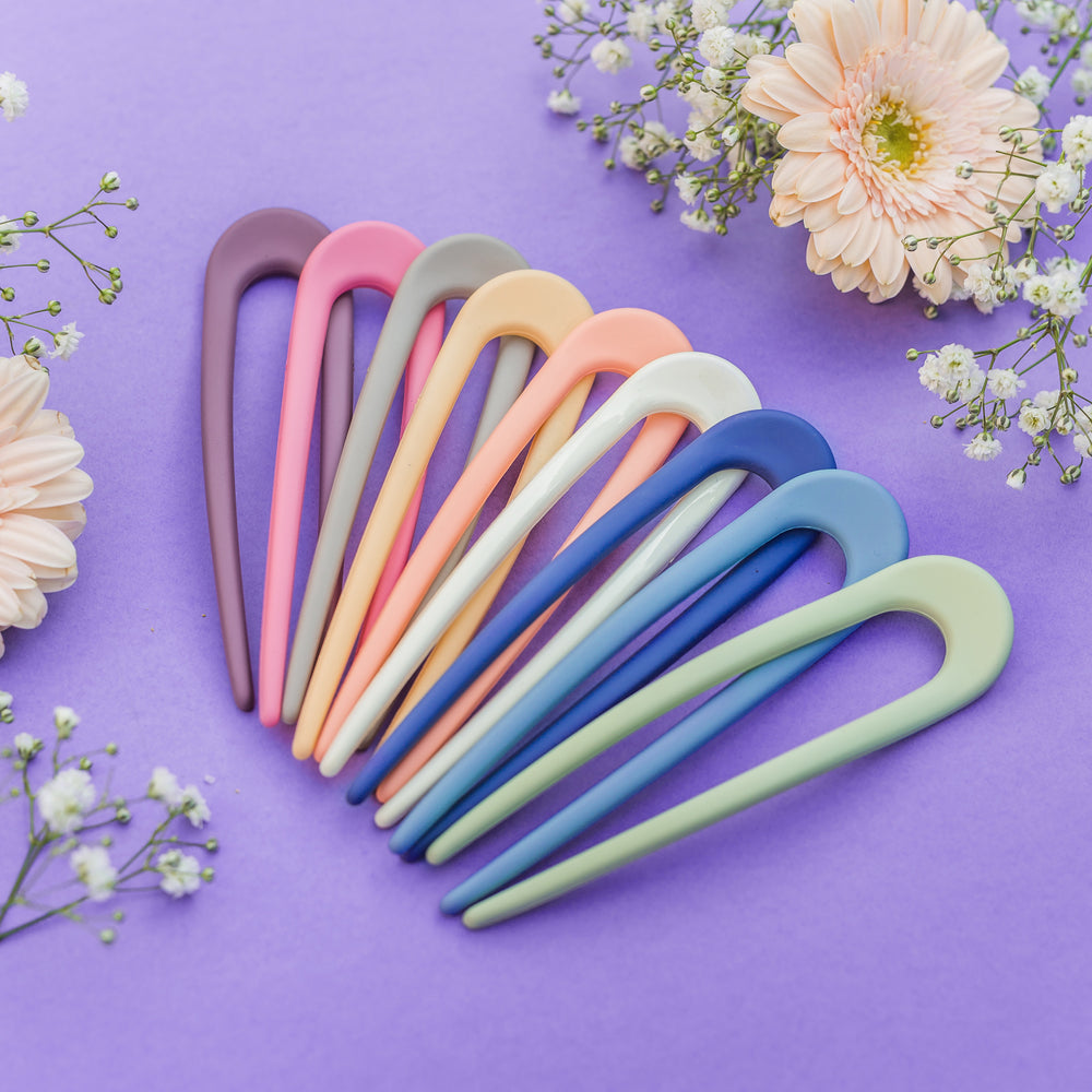 pastel haarpinnen set multicolor haaraccessoires op paarse achtergrond met bloemen