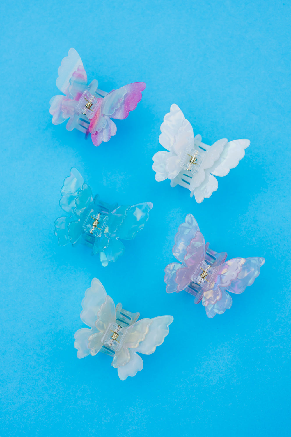 transparante bloem haarclips pastel kleuren op blauwe achtergrond trendy haaraccessoires set